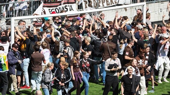 Fans des FC St. Pauli demontieren nach dem Schlusspfiff die Tornetze, um sich ein Erinnerungsstücks des Auftiegs 2024 zu sichern. © IMAGO / osnapix 